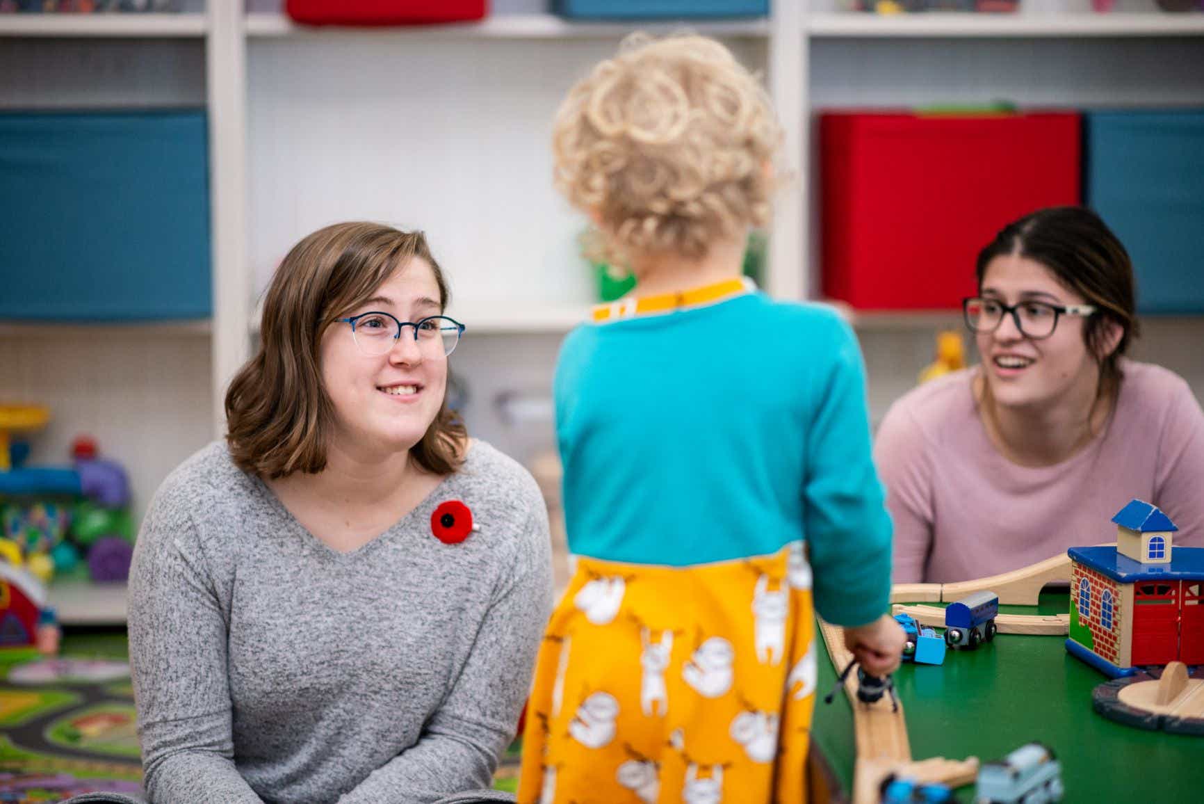 An Early Childhood Educator interacts with a child in a childcare environment.